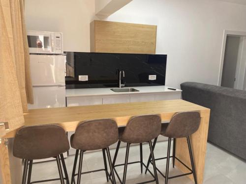 a kitchen with a counter with three chairs and a sink at בוטיק צ'יל אאוט - Boutique Chill Out in Eilat