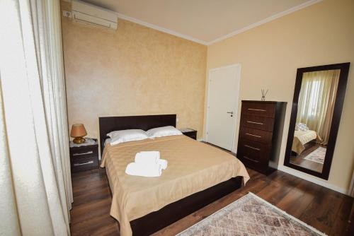 1 dormitorio con 1 cama grande y espejo en Casa di Besarb, en Shkodër