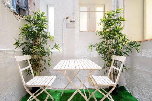 einen Tisch und zwei Stühle neben einer Wand in der Unterkunft Cosy interior ground floor in Barrio Salamanca-BOC5 in Madrid