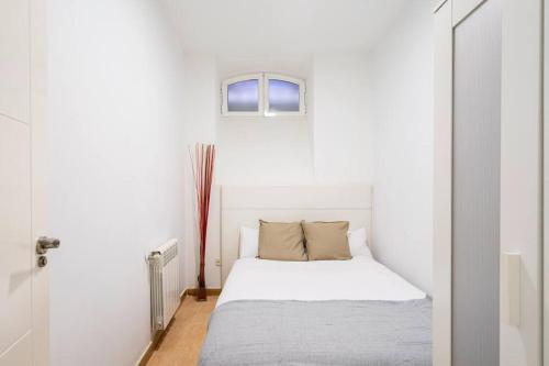 a white bedroom with a bed and a window at Cosy interior ground floor in Barrio Salamanca-BOC5 in Madrid