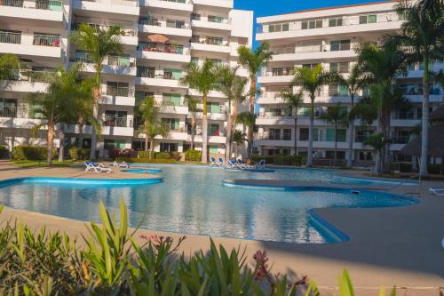 a swimming pool in front of a large apartment building at Hermoso en marina, asombrosas vistas by G P S rentas in Mazatlán