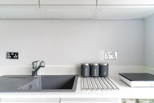 a kitchen counter top with a sink and a sink at Luxury 5BD Suite Guest House in London