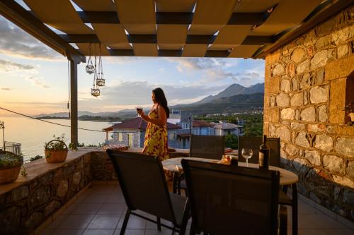 a woman standing on a balcony looking out at the water at Σελήνη in Kotrónion