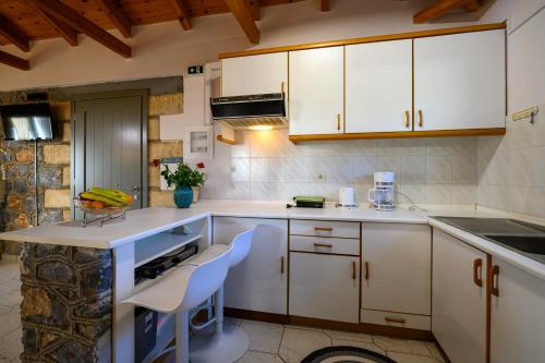 a kitchen with white cabinets and a counter top at Σελήνη in Kotrónion