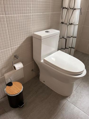 a bathroom with a white toilet and a trash can at Habitación privada con baño in Lima