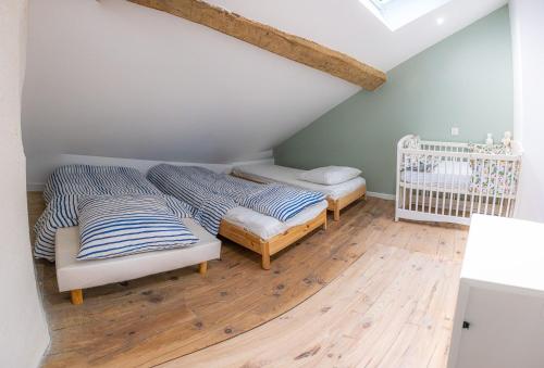 - une chambre mansardée avec 2 lits et un lit bébé dans l'établissement Maison de Vacances à la montagne, à Laruns