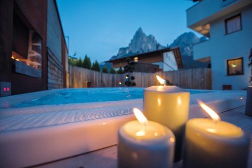 two candles are sitting next to a swimming pool at Apartment Sella in Siusi