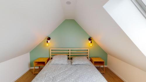 a bedroom with two beds in a attic at Charmante Maison en Pierre - Centre Ville - Plage in Ouistreham