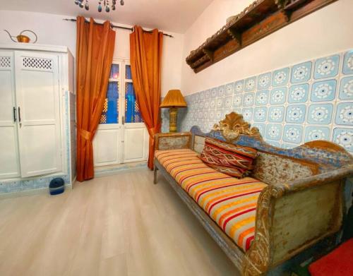 a living room with a couch and a window at Agréable maison traditionnel au cœur de la Marsa in Douar el Hafey