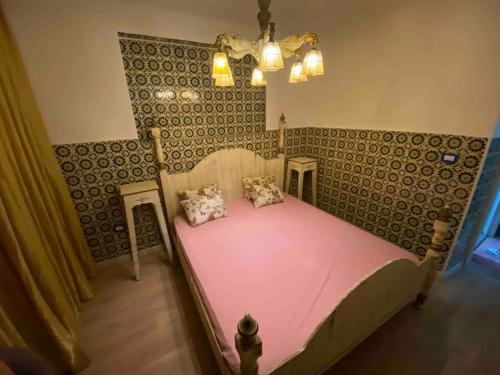 a bedroom with a large pink bed with two pillows at Agréable maison traditionnel au cœur de la Marsa in Douar el Hafey