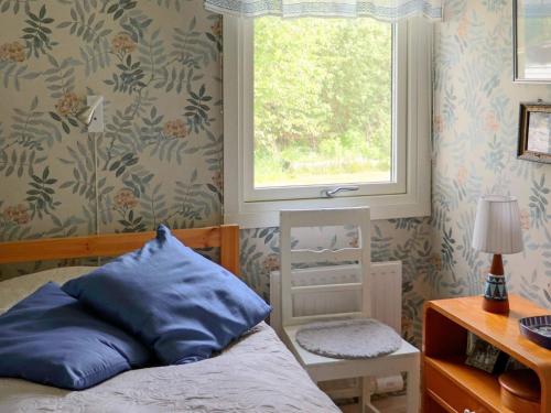 um quarto com uma cama com uma almofada azul e uma janela em Holiday home VARBERG XXI em Varberg