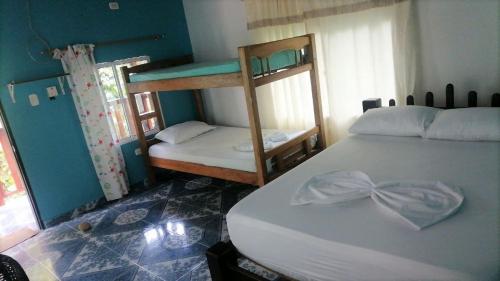 a bedroom with two bunk beds in a room at Hostal Recuerdos del Tayrona in El Zaino