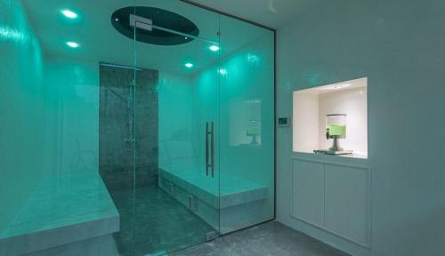 a bathroom with a glass shower with a lamp in it at Crown Royal Luxury Villa Estates in Rhodes Town