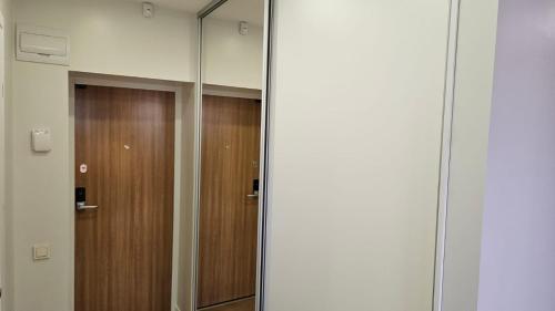 a mirror in a room with a wooden door at Modern Studio Apartment in Marijampolė