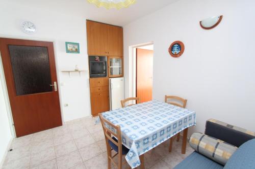 a kitchen and dining room with a table and a couch at Apartments Lunjski in Lun