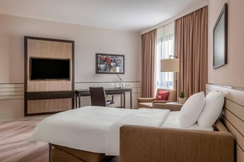 a hotel room with a bed and a desk at Munich Airport Marriott Hotel in Freising