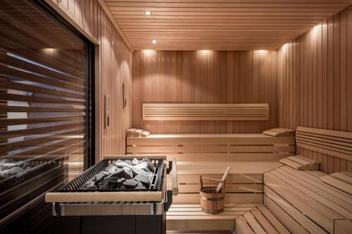 a sauna with a tub and a grill in it at Munich Airport Marriott Hotel in Freising