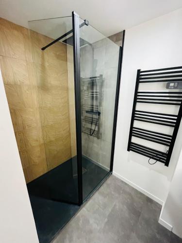 - une douche en verre dans une chambre avec un mur dans l'établissement Charmante Maison en Pierre - Centre Ville - Plage, à Ouistreham