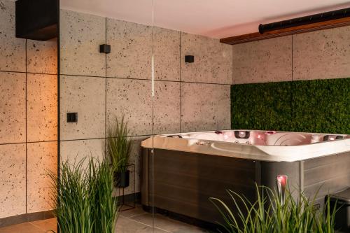 La salle de bains est pourvue d'une baignoire et de quelques plantes. dans l'établissement Widokowa Villa TOP - ADULTS ONLY, à Kościelisko