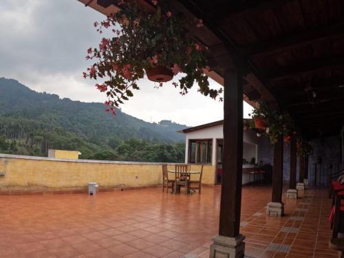 une terrasse couverte d'une maison avec une table et des chaises dans l'établissement Hotel El Mirador Anexo 1, à Santa Lucía Milpas Altas