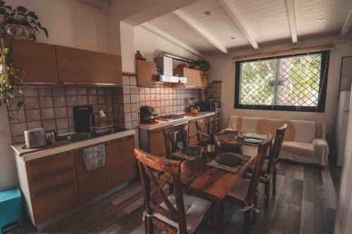 a kitchen with a wooden table and chairs in a room at Eleutheria beach villa by the beach in Torre Chianca