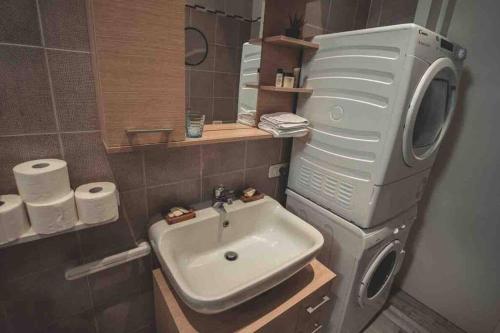 a bathroom with a sink and a washing machine at Eleutheria beach villa by the beach in Torre Chianca