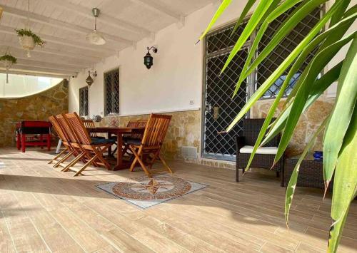 a dining room with a table and chairs at Eleutheria beach villa by the beach in Torre Chianca