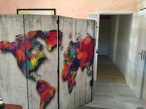 a wooden door with a painting of a world on it at Eleutheria beach villa by the beach in Torre Chianca