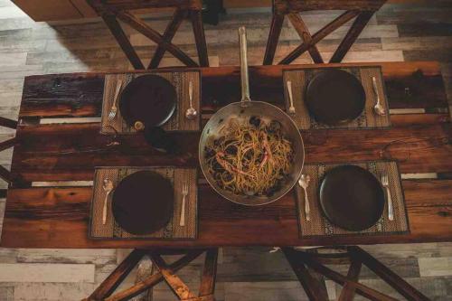 a bowl of noodles on a wooden table at Eleutheria beach villa by the beach in Torre Chianca