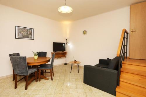 ein Wohnzimmer mit einem Tisch und einem Sofa in der Unterkunft Casa Santo e Albina Rabac in Rabac