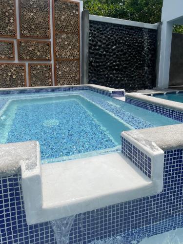 a swimming pool with a tile floor and a poolvisor at Johnnys Place Hotel in Monterrico