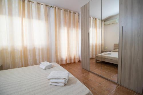 a bedroom with a mirror and a bed and a bed sidx sidx sidx at Casa Wendy in SantʼAntìoco