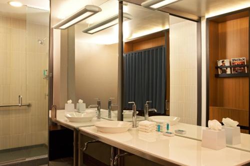 a bathroom with three sinks and a large mirror at Aloft Ontario-Rancho Cucamonga in Rancho Cucamonga