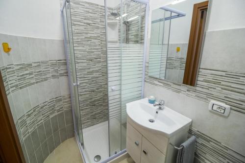 ein Bad mit einem Waschbecken und einer Dusche in der Unterkunft Casa Wendy in SantʼAntìoco