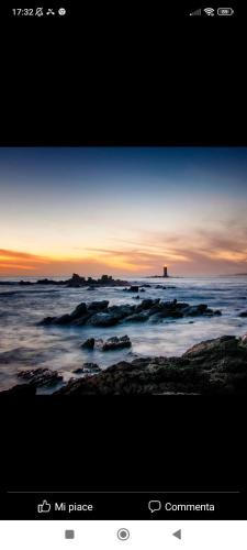 a view of the ocean with a lighthouse in the horizon at Casa Wendy in SantʼAntìoco
