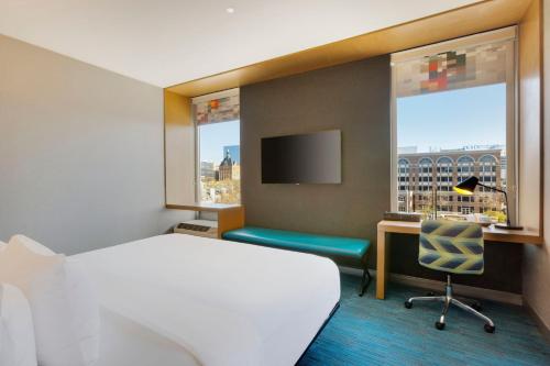 a hotel room with a bed and a desk and a window at aloft Hotel Milwaukee Downtown in Milwaukee