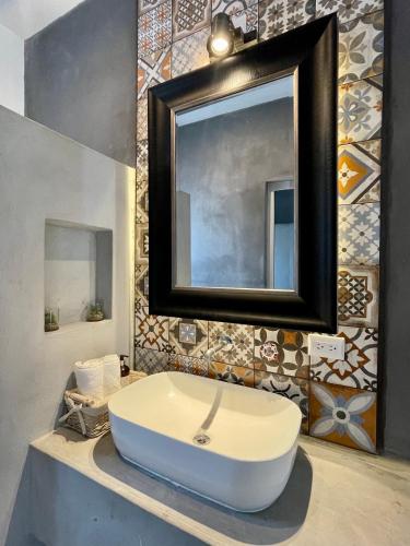 a bathroom with a sink and a mirror at Johnnys Place Hotel in Monterrico
