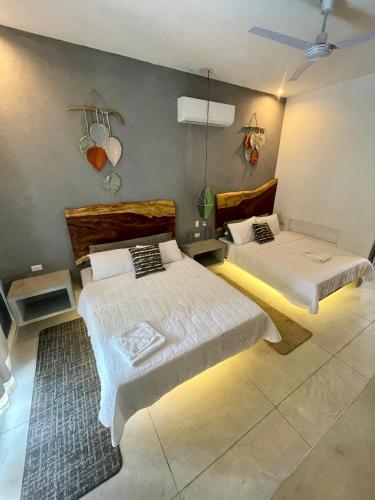 a bedroom with two beds with lights on the wall at Johnnys Place Hotel in Monterrico