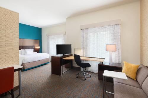 Habitación de hotel con cama y escritorio con sofá en Residence Inn by Marriott Spartanburg Westgate en Spartanburg