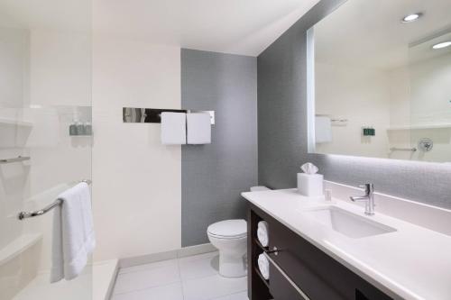 a bathroom with a sink and a toilet and a mirror at Residence Inn by Marriott Spartanburg Westgate in Spartanburg