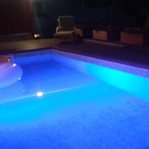 a swimming pool lit up at night with a chair at Karolingerweg in Lauterhofen
