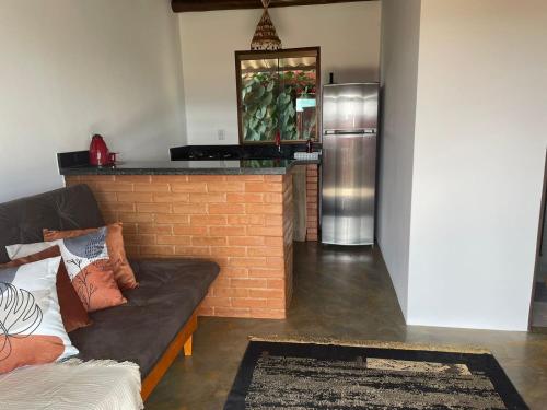 ein Wohnzimmer mit einem Sofa und einem Kühlschrank in der Unterkunft Lobo Guará Hospedagem Loft in Alto Paraíso de Goiás