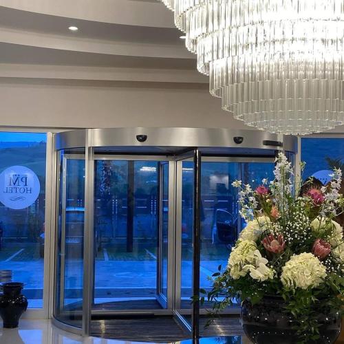 カタンツァーロ・リドにあるPM Hotelの大きなシャンデリアと花が飾られたロビー