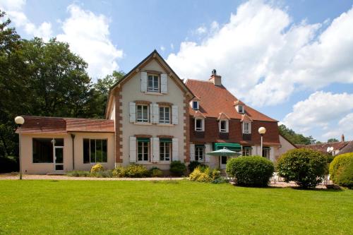 a house with a green lawn in front of it at Le Tronçais in Saint-Bonnet-Tronçais