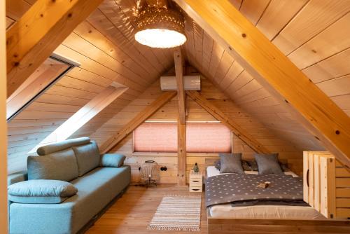 a room with a couch and a bed in a attic at Glamping Happiness with Sauna and Natural Pool in Ribnica