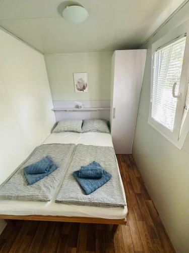 a bedroom with a bed with two blue pillows on it at Mobile home SIMS in Biograd na Moru