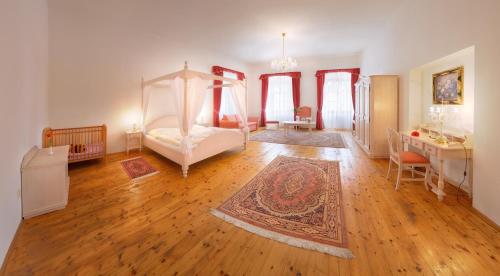 a bedroom with a canopy bed and a wooden floor at Hotel Růže in Rožmberk nad Vltavou