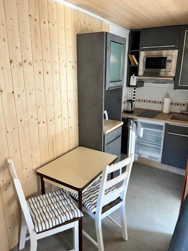 a kitchen with a table and a chair and a table and a kitchen at Peeneurlaub in Lassan