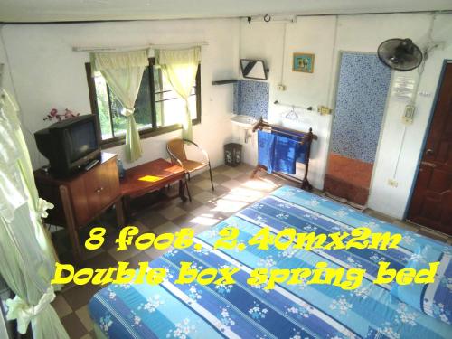 a living room with a bed and a tv at Residence House in Trat
