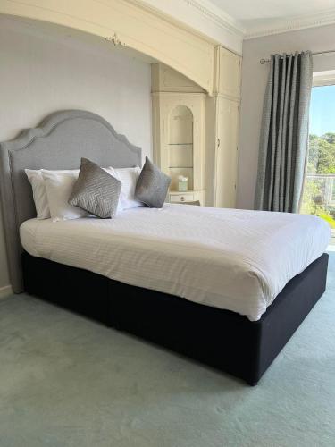a large bed with two pillows on it in a bedroom at The Riviera Hotel & Apartments - Alum Chine in Bournemouth